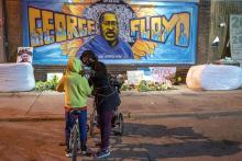 Shannon Haynes talks with her son, Ronald, 9, about George Floyd in front of a memorial. On April 20, former Minneapolis Police Officer Derek Chauvin was found guilty of two counts of murder and one of manslaughter in Mr. Floyd's death.